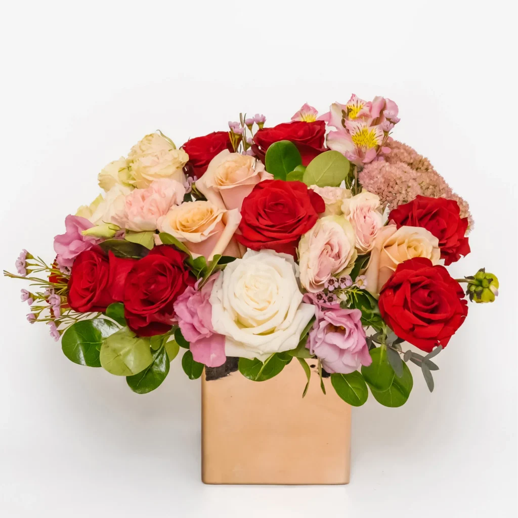 Ecuadorian Passion Deluxe arrangement with abundant red, white and blush roses, pink lisianthus and premium seasonal flowers in a ceramic vase. Perfect for romantic occasions, anniversaries and special celebrations. Same-day flower delivery in Los Angeles, California. Fresh premium flower bouquet handcrafted by local florist.